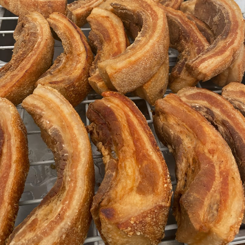 Crispy, golden-brown Filipino pork belly (Mang Eton's Lechon Kawali) pieces resting on a metal rack.