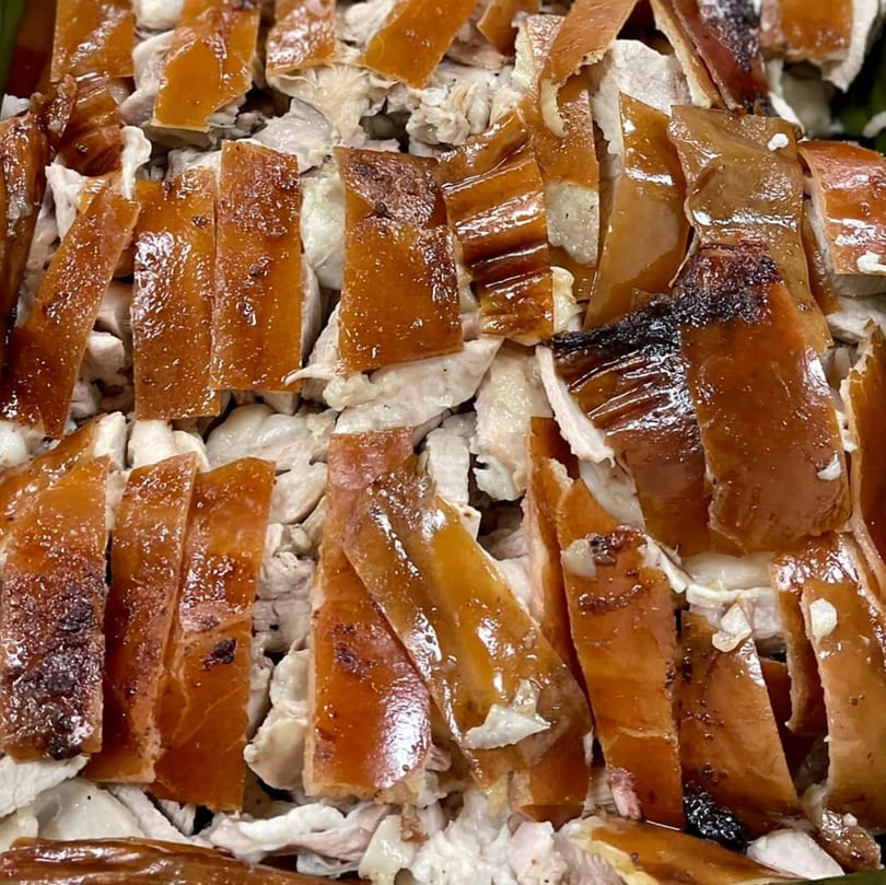 Close-up of chopped Filipino lechon, showing crispy golden-brown skin and tender white meat.