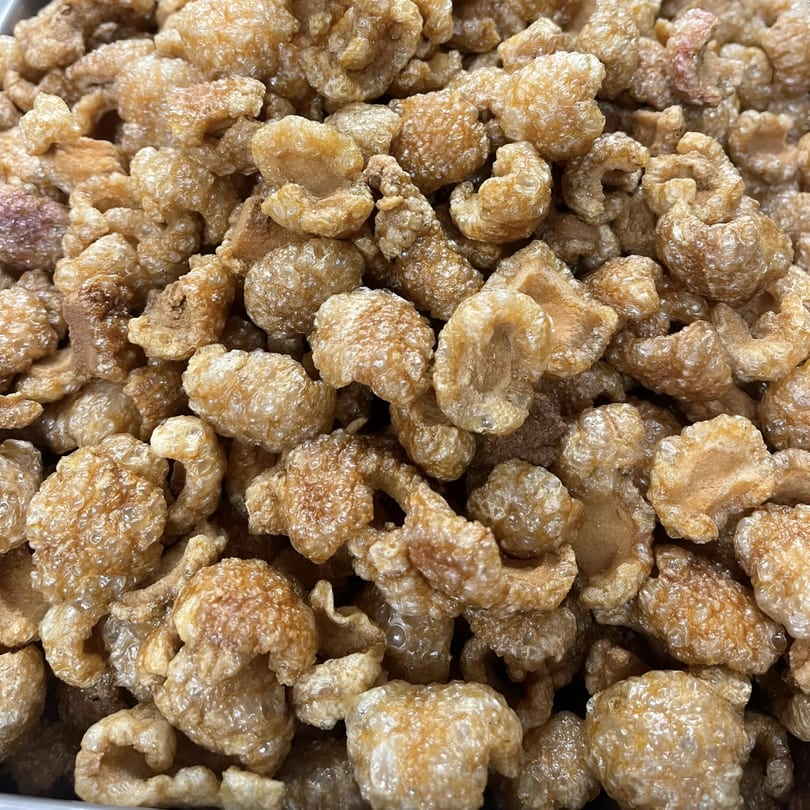 Close-up of a large pile of golden-brown, crispy Filipino chicharon (pork rinds).